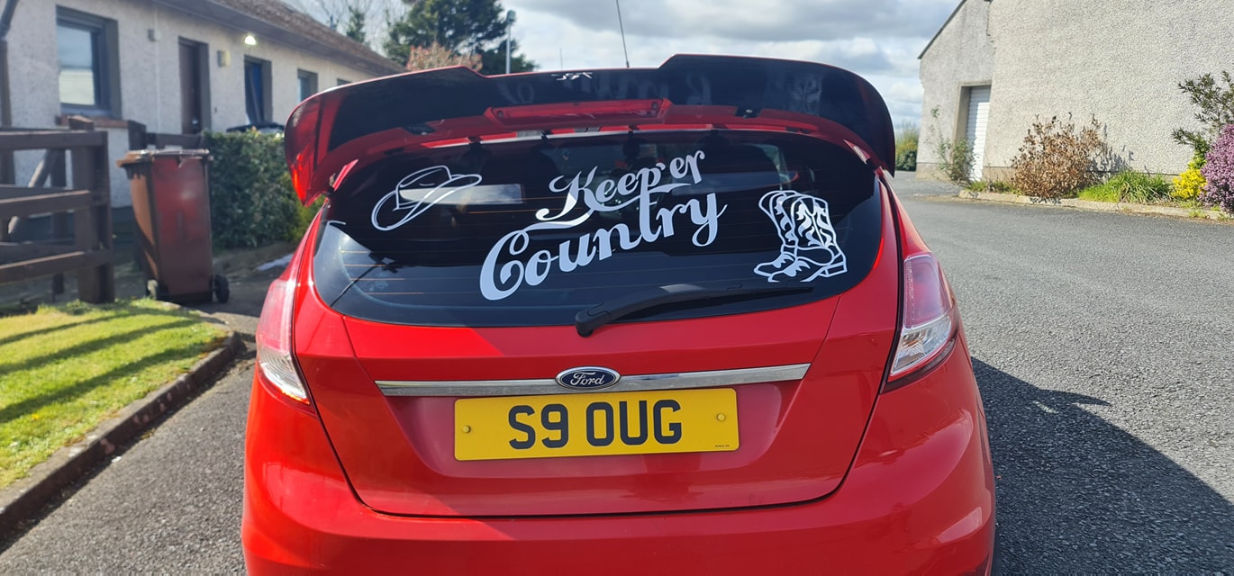 Custom white rear window decal on a red car